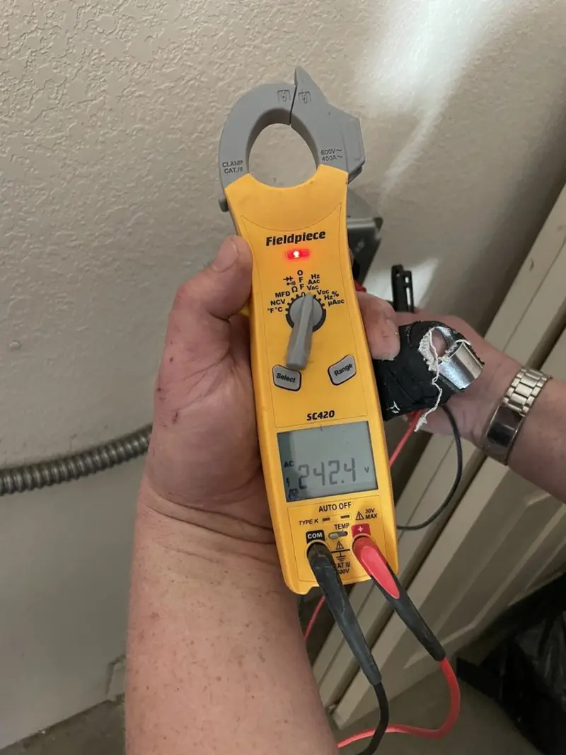 Voltage testing with clamp meter during Outlet Installation in Rio Communities